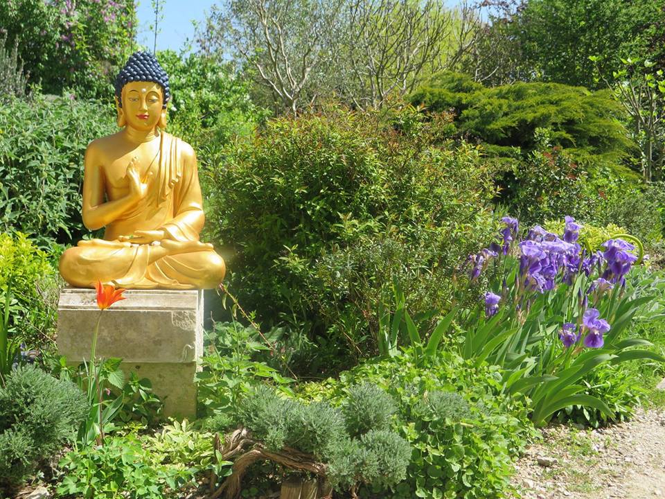 Une statue du bouddha dans le jardin de l'Institut Vajra Yogini