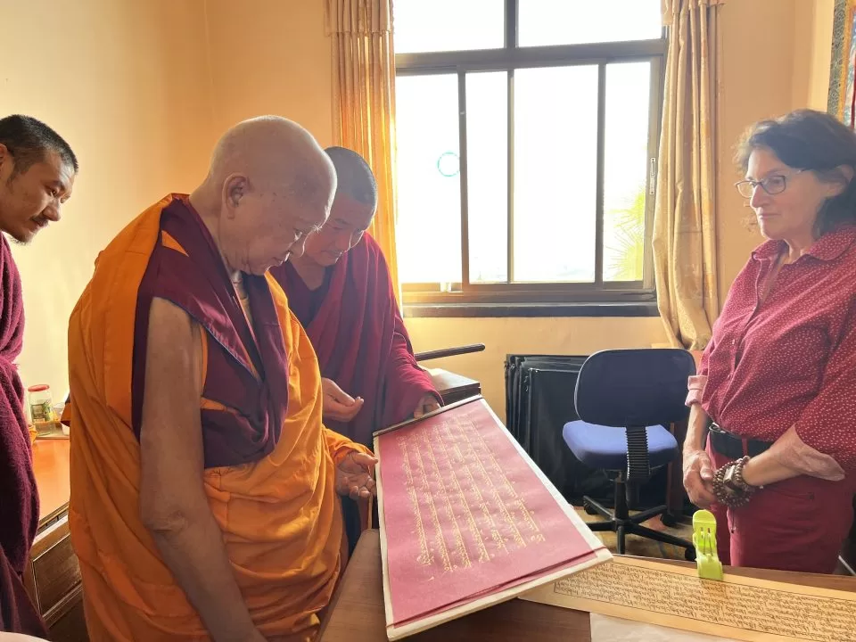 Lama Zopa Rinpoché, vérifiant l'écriture du soutra de la Prajnaparamita au Népal en 2022, avec Vén. Tsering et Jane Seidlitz.